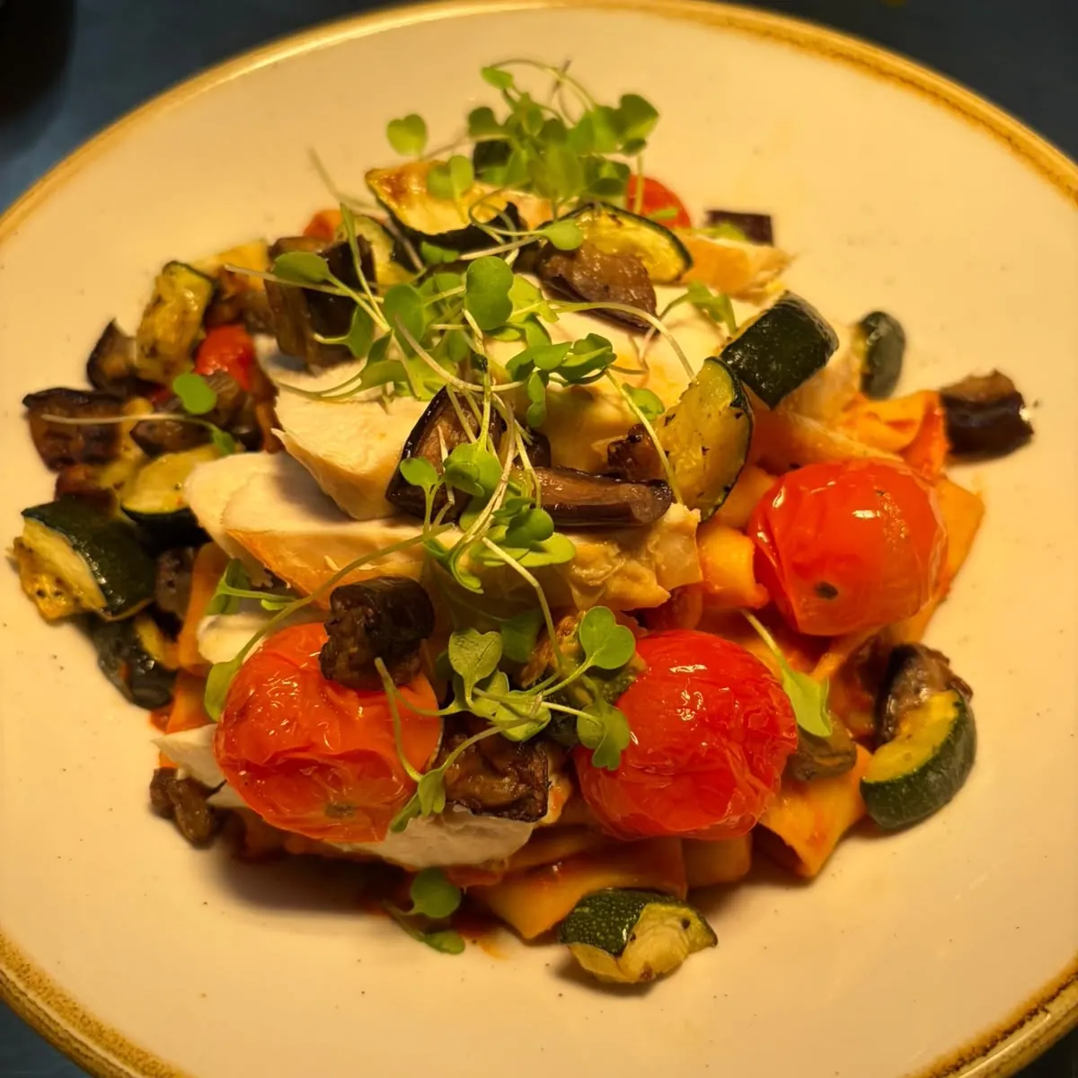 Pappardelle in tomato sauce with sliced chicken, roasted courgette and aubergine, blistered cherry tomatoes and micro herbs