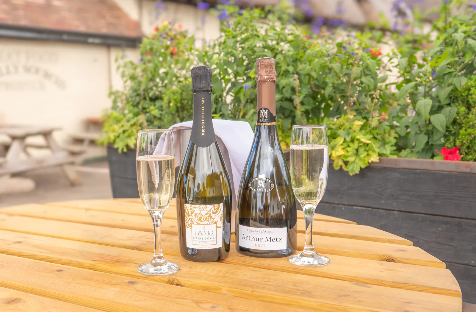 Prosecco and cremant on ice with two filled flutes on a table outside at The Crown