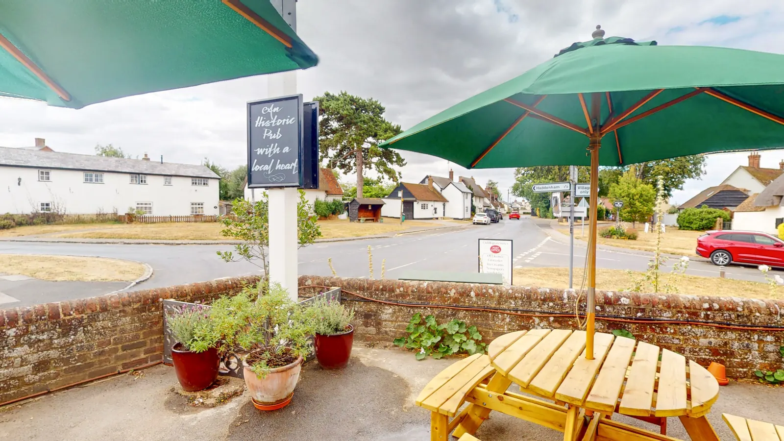 A table outside The Crown looking out over the village green and the Aylesbury Road