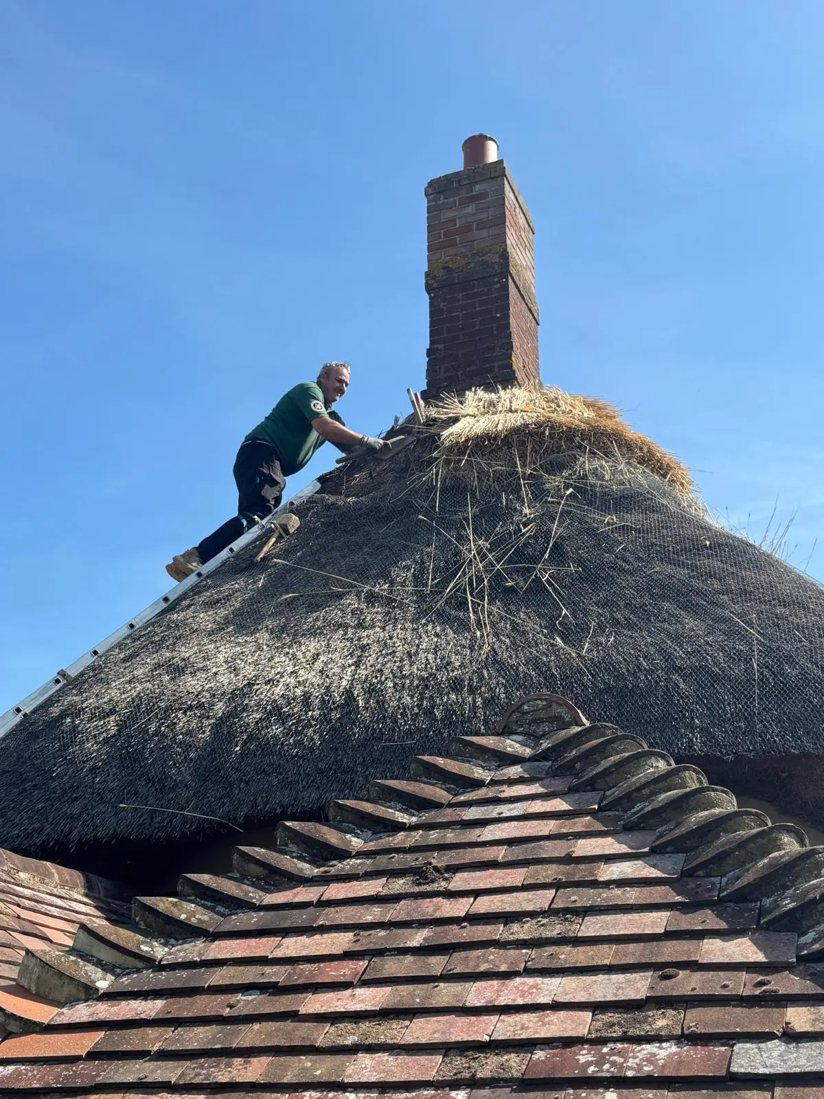 A thatcher at work below the chimney